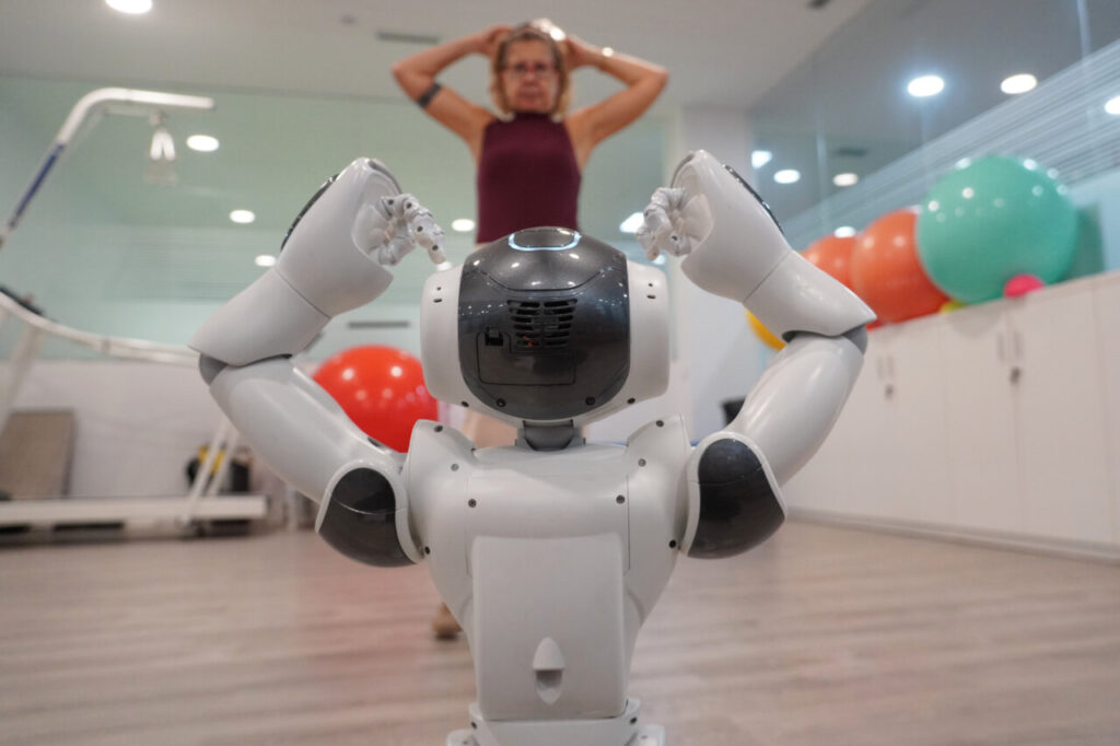 Robot asistencial interactuando con una persona en un entorno de rehabilitación