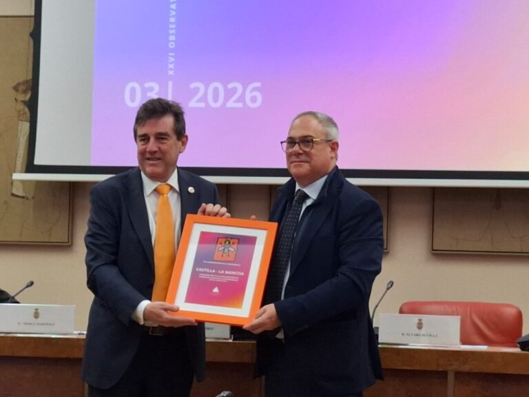 Dos hombres sosteniendo un premio en un evento sobre dependencia en Castilla-La Mancha