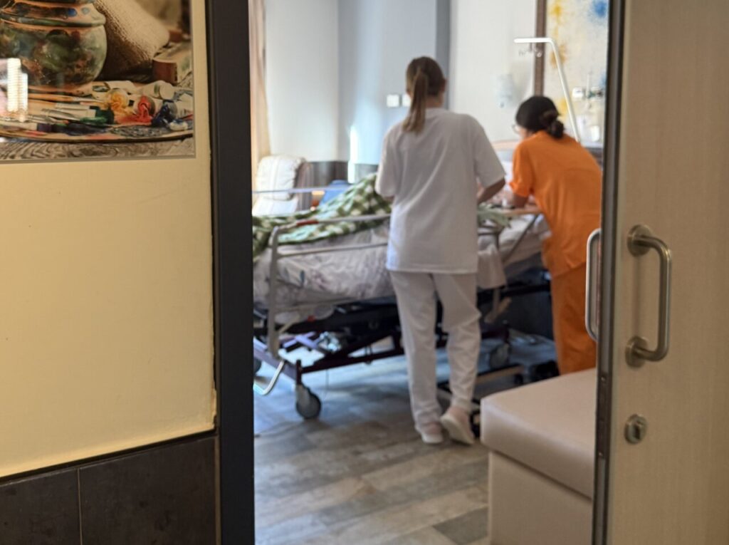 Dos profesionales de la salud atendiendo a un paciente en cuidados paliativos