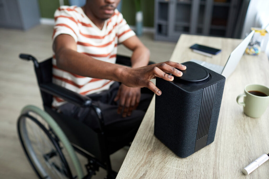 Persona en silla de ruedas interactuando con un dispositivo tecnol&oacute;gico