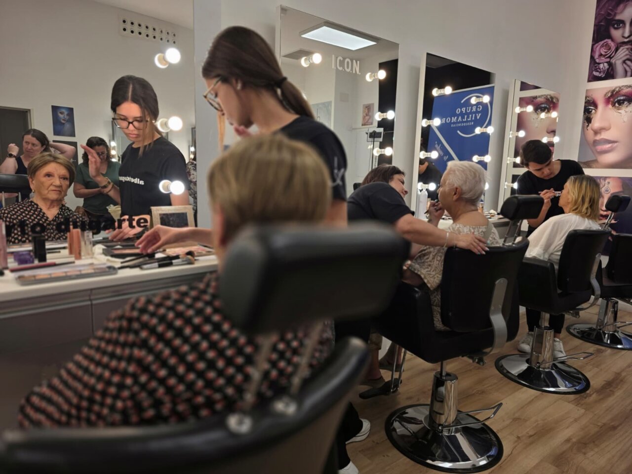 Equipo de maquilladores trabajando con mujeres mayores en un sal&oacute;n