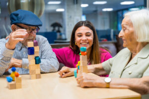 Personas mayores jugando con bloques en un centro de atenci&oacute;n diurna