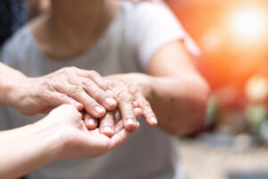 Manos de personas en un contexto de apoyo y tratamiento médico de Parkinson
