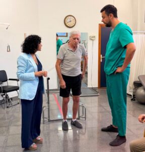 Visita a un centro de atención social con profesionales y un paciente.