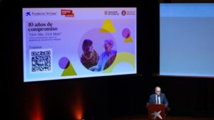 Un hombre habla desde un atril ante una pantalla del foro Vivir Más, Vivir Mejor.