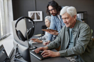 Personas mayores interactuando con tecnología en un entorno de aprendizaje.