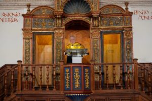 Valentín Fuster habla desde un atril ante un retablo de madera ornamentado.